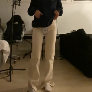 Sandfärgade Jeans med slits  - ( ljusare i verkligheten, ser mörkare ut på bilden) Som ni ser på bilden är de alldeles för långa, jag är 158 ungefär. De skulle nog passa någon mellan 165-173. Helt nya  använts endast för att se hur det sitter på. Jätte fina sandfärgade slit jeans