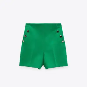 Ett par gröna shorts med guldiga detaljer nyligen köpt från zara med prislappen kvar.     