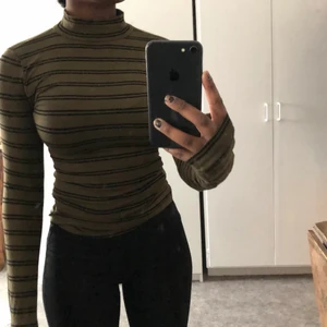 Polotröja strl S - Grön polotröja med svarta ränder, använd ett fåtal ggr, skön att ha på sig även om den sitter tight mot kroppen 