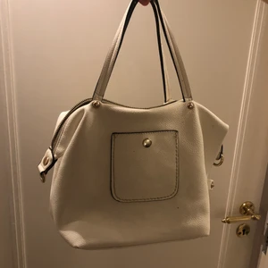 Väska - Supersnygg handväska som man kan knäppa på ett extraband så att den blir längre. Passar till alla outfits. Köpt secoundhand