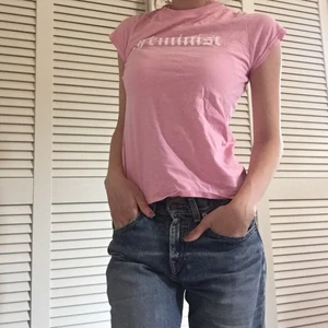 Rosa t-shirt - Säljer denna rosa t-shirt med texten ”feminist” från madlady. Den är i bra skick och är inte mycket använd✨