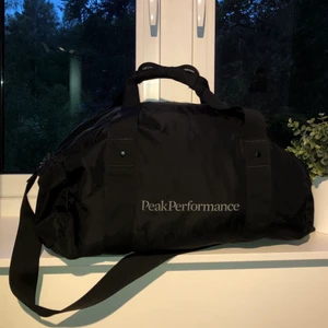 Peak performance väska - Stor och djup väska som du båda kan bära me axelrem och som en vanlig ryggsäck, 3 st djupa fickor inuti plus en stor ficka utanpå, du kan ta bort spännerna på sidorna så du kan ta bort Axelremmen (som du ser på bilden). Ägt den i 4 veckor som gymväska så inte en skada på.