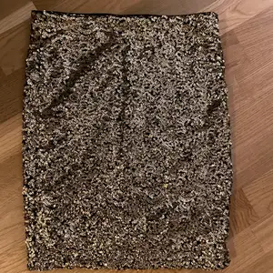 Denna kjol är svart med massa små guldiga paljetter. Den är köpt från H&M DIVIDED och är i storlek xs. Kjolen är mycket sparsamt använd och är i jättebra skick. Den sitter tajt men har en resor i midjan. Vid intresse är det bara att höra av sig! :)