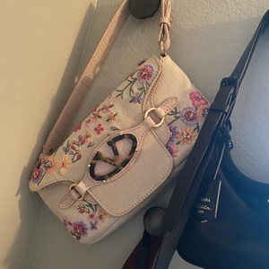 Valentino väska - Säljer min fina sällsynta vintage valentinoväska. Beige/vit färg på väskan. Med tvp fack. Bandet är rosa och justerbart. Inga defekter och väldigt lite använd