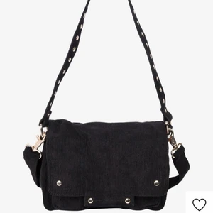 Nunoo väska - En nunoo (honey corduroy) väska i svart med gulddetaljer. Köpt för 6 månader sedan och är i gott skick! Ursprungligt pris 1199kr.