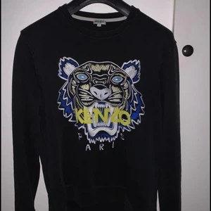 kenzo sweatshirt storlek S - Svart kenzo sweatshirt storlek S. Tröjan är självklart äkta och säljs pågrund av att den inte kommit till användning så mycket. Skicket 8/10 ända är ett mycket litet hål som är lagat och absolut inte syns vid användning eller på bilderna. Priset är inte hugget i Sten!