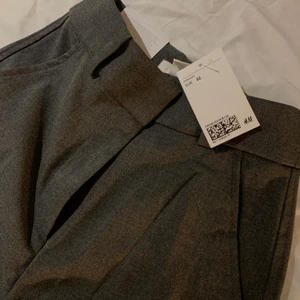 Kostymbyxor  - Säljer mina oanvända mörkgråa kostymbyxor från H&M i storlek 32. Passar perfekt men var tyvärr för korta för mig. Säljer pga att det inte gick att lämna tbx då jag tappade bort returetiketten. Frakt tillkommer☺️ Vid intresse/frågor, tveka inte att kontakta mig!✨💕