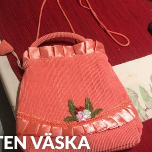Liten väska - Liten väska som är handgjorda i mjuk tyg . Har en axelband och en handtag .oanvänd .höjd 22cm och bred 20 cm