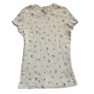 Blommig T-shirt  - Ribbad T-shirt med blommor på! Storlek XS men passar mig med S också! 