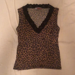 Leopard linne - Jättefint linne med spets i kanterna. Har ett hål på framsidan, den köptes så. Hålet syns inte på håll. 