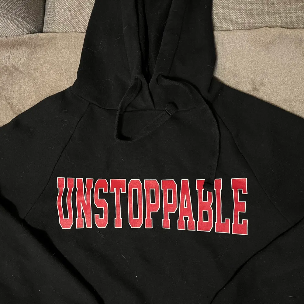 En svart hoodie med rött/vitt tryck. Storlek S och inte andvänt på ca 2 år. Endast bara legat i min gaderob oanvänd. Hoodies.