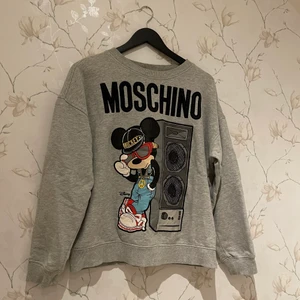 Moschino - En grå tröja från H&Mx Moschino serien. Endast använd ett fåtal gånger. Nypris: 700kr