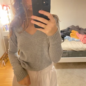 Stickad grå tröja - Stickad grå tröja med V-ringning från Brandy Melville, köpt i London. Bra skick!