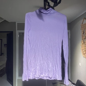 Ljuslila polotröja - Ljuslila polotröja i mjukt och väldigt skönt material. Den har väldigt långa armar som når mitten av handen. Köpt på secondhand men aldrig använd av mig. 
