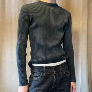 Grå-blå ribbad tröja - Grå-blå stickad tröja i slimfit. Sitter superfint och är i bra skick. Jag är 182cm lång. Frakt tillkommer på 66kr (postnord spårbart) 
