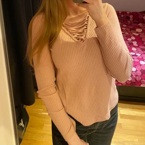 Gammelrosa tröja med snörning fram - En gammelrosa tröja med snörning fram. Snörningen fram går inte att ändra på själv.