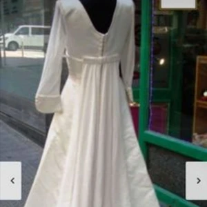 Brudklänning vintage - Vacker, tidlös och elegant brudklänning från spanskt designermärke, Jesus Peiro.  Originell och mycket välgjord med lyxigt tyg och fina, enkla detaljer.  Köpt från en vintagebutik men jag kan inte exakt datera den. En mindre fläck är synlig på bild 3. Jag har själv inte försökt rengöra den.  Bilderna är från tidigare försäljning.   Passar stl. S-M och en person som är runt 160-165 cm lång)