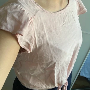 Topp med knut därframme  - Väldigt söt rosa topp från Bershka med en knut därframme man kan göra till rosett om man vill 🌸 Fina  ärmkant som är lite som volanger ✨ Inga missfärgningar eller hål 