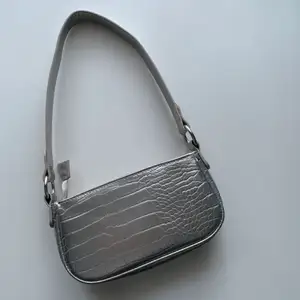 En väska i silver som jag köpt här på Plick men som ursprungligen är från Asos. Sparsamt använd. Jag säljer då den inte kommer till användning. 