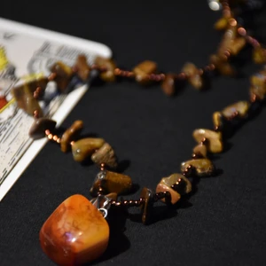 Halsband kristaller  - Halsband med tigeröga och bronsfärgade pärlor samt ett hänge av karneol. 