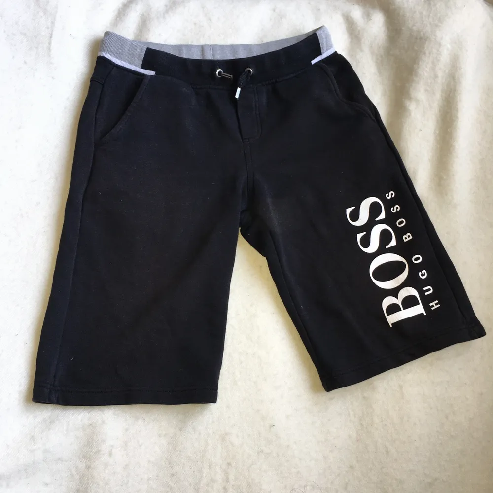 Svarta Hugo Boss shorts kidswear storlek 12, XS. Shortsen är i mycket gott skick förutom ett lagat hål bak, därför lågt pris.. Shorts.