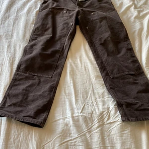 Carhartt double knee work pants vintage - Ett par jättecoola och snygga carhartt double knee byxor. Väldigt bra skick för att vara vintage. Väldigt bra material som är slitstarkt. Finns ingen sizetag men dem e som 34/34