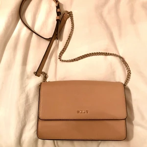 Väska flap-bag DKNY  - Säljer min axelremsväska från DKNY då den inte kommer till användning längre! Beige i färgen och är använd men i bra skick. Bud eller direktpris kan fås 🌸🌸🌸