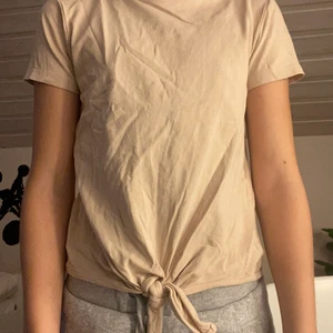 Rosa/begie t-shirt - En rosa/begie t-shirt med en Knut vid midjan!