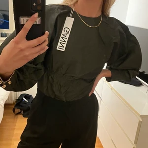 Ganni ”shiny chino blus” - Jättefin blus från Ganni! Helt oanvänd med etikett fortfarande kvar. Kostar ursprungligen 2049kr. Kund står för frakt! (49kr). Pris är förhandlingsbart!