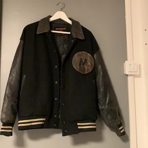 Varsity jack läder - En snygg varsity jack med skin armar i bra skick utan hål och märken men skinnet på armarna ljusnat lite på några få ställen