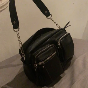 Snygg svart väska🖤 - En snygg  svart konstläder (alltså inte äkta läder) axelräms väska med två axel remar i olika längder, med silver kedjor🖤 Från Pieces. Den är använd 1 gång och är i ett bra skick! 