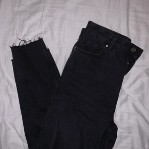 Svarta raka jeans från bikbok - Säljer dessa svarta jeansen från bikbok i rak modell och slitningar längst ner. Höga i midjan! Storlek S, använda max 3 gånger. Ingen dragkedja, endast 4 knappar som inte syns när man knäppt utan göms bakom extra tyg.