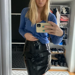 Kjol med glansig yta - Kjol med glansig yta, två fickor och dragkedja där fram💕 Fint skick, storlek 38