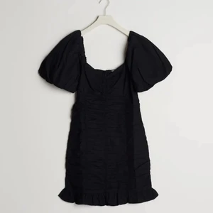 Svart klänning  - Kort klänning med en figurnära passform. Klänningen är perfekt för festen och svart och har korta puffärmar. Aldrig använd 🥰