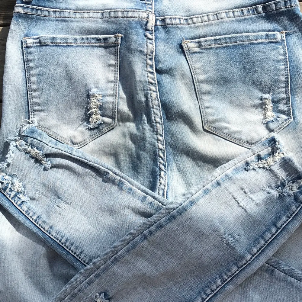 Ett par ljusblåa skinny jeans med hål i och fransar längst ner. Materialet är stretchig. Knappen sitter lite lös men jag testade och det utgår ingen fara, den sitter fast. . Jeans & Byxor.