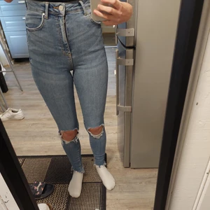 Högmidjade jeans med hål - Snygga tighta jeans med hål, storlek xs, väldigt stretchiga. Inte använt så mycket där av säljer jag dom. Köparen står för frakten. ❤ jag är 160 och brukar vika upp kanten då dom är lite långa för mig 