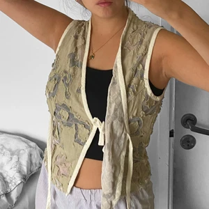 Linne - Unikt linne/blus som man knyter både innanför och utanpå. Felfri. Färgen är beige/grå 