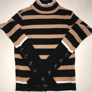 Ribbad polo-tröja strl. S - Beige-svart randig, ribbad polotröja från Zara i storlek S. Knappar från armbåge till ärmslut. Normal i passform.