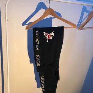 Air Jordan Trackpants - Svarta Air Jordan trackpants i storlek extra small. Broderade Air Jordan stripes längs sidan på varje ben och logga över vänster lår. Två fickor och en ficka bak som stöds med knapp. Köpt på FootLocker för 900kr.