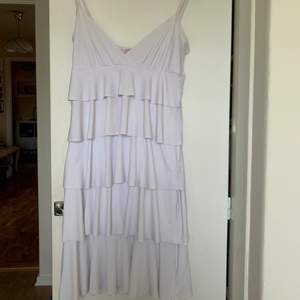 fin vit klänning med volanger. den har en liten fläck på framsidan (bild 3) men den syns inte så mkt. storlek medium