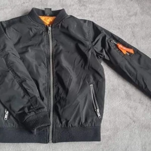 Bombarjacka strl 116 - En svart bombarjacka i strl 116. Gott skick.