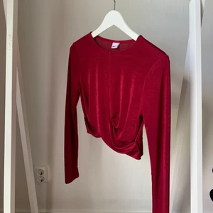 Vinröd glansig topp Gina Tricot strlk M - Vinröd långärmad topp från Gina Tricot storlek M. Lite glansig i tyget, med en knut framtill, snygg till fest! 92% polyester 8% elastan. Inget att anmärka på, använd endast en gång och tvättad en gång. Pris: 50kr + 66kr frakt. 