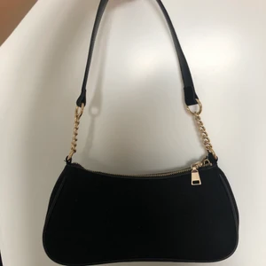 Oanvänd väska från H&M  - Säljer nu denna fina lilla baguette väska då den inte har kommit till användning. Det finns även en förlängt axelband till väskan. Köparen står för frakt