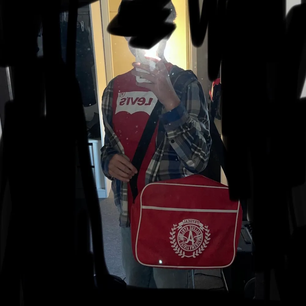 En röd physical väska med dragkedja och svarta band👍🏻💕+fram fack. Fina mycket rum💕. Väskor.