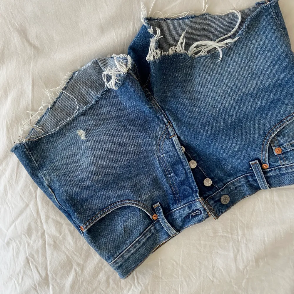 Helt oanvända trendiga  Levis shorts i en ljusare jeans färg! Plagget är helt oanvänt och är i storlek W27. Perfekta att ha i sommar till stranden eller liknande. Storleken passar en (S/M). Vid ev frakt står köparen för frakten. Shorts.