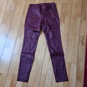 Coated vinröda byxor med coola zippers. - Coated vinröda byxor som sitter SÅ snyggt på.  De är aldrig använda.