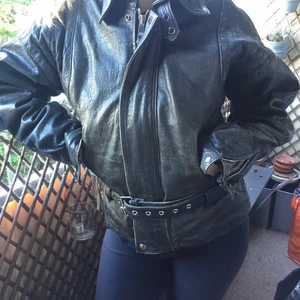 Läderjacka i grått med bälte  - Skinn/läder paj i bikermodell. Skärp i midjan och en snygg gråaktig färg. 