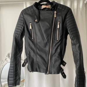 Chiquelle fakeskinn motojacket, st 38 - En skinnjacka i fake skinn från chiquelle, har haft den hängd i garderoben i ca 3-4 år, använd 2 gånger så den kommer i princip nyskick förutom lappen i kragen då det är via den jackan har hängt. Har ej bilder på hur den sitter på då den är för liten för mig, den är storlek 38/medium men skulle säga att den passar bäst på xs/s 34/36 då den är mycket liten i storleken.