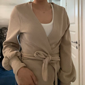 Gina Tricot kofta S - En underbar beige kofta/tröja från Gina i S🪐 Så himla mysig och skön. Går att knyta men man kan även helt ta av ”snöret”🤍🤍. Nästan helt oanvänd, som ny :)