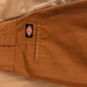 Dickies byxor dam  - Ett par bruna dickies byxor i jättebra skick. Endast använda 1 gång. Jag är 172 cm lång så och de går nästan ner till fötterna. Skick: 10/10 